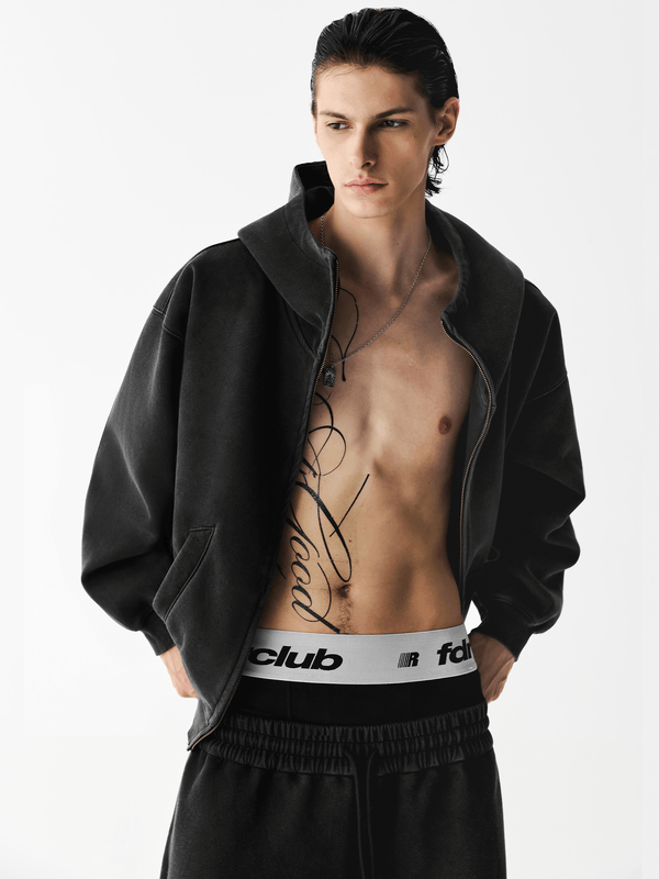 Male model wearing an unzipped black hoodie showing cropped inner styling.