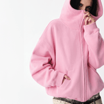 Front half-body view of a female model wearing a pink high-neck zip-up hoodie.
