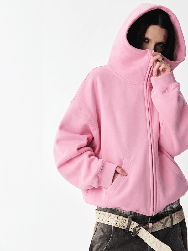Front half-body view of a female model wearing a pink high-neck zip-up hoodie.