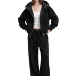 Full body view of a female model wearing the black colorway of the unisex baggy cyber y2k tracksuit, featuring an oversized zip-up hoodie and relaxed wide-leg sweatpants.