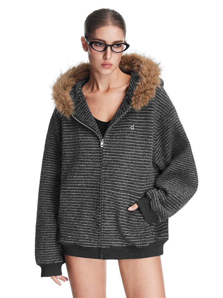 Model wearing dark grey textured zip-up hoodie with brown faux fur trim hood, high-street fashion aesthetic.