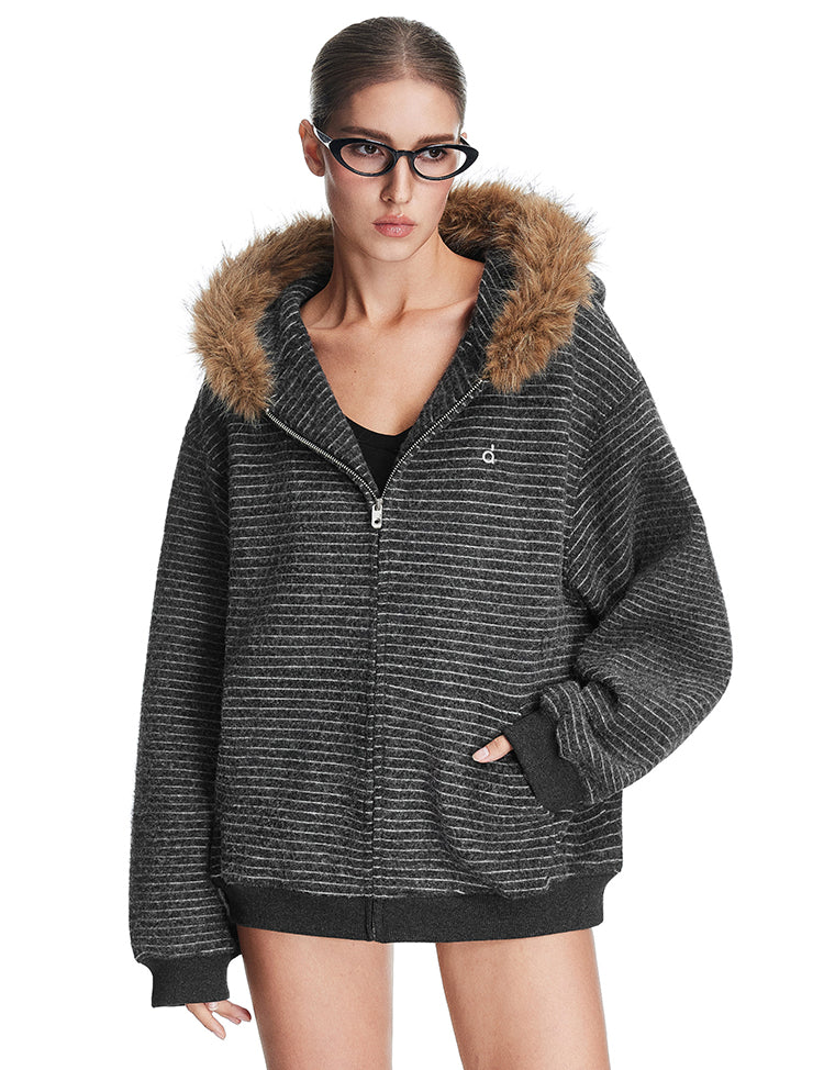 Model wearing dark grey textured zip-up hoodie with brown faux fur trim hood, high-street fashion aesthetic.