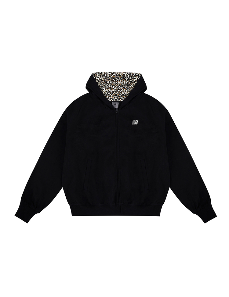 Flat lay of black zip-up hoodie with leopard print lined hood and cat ears on white background.