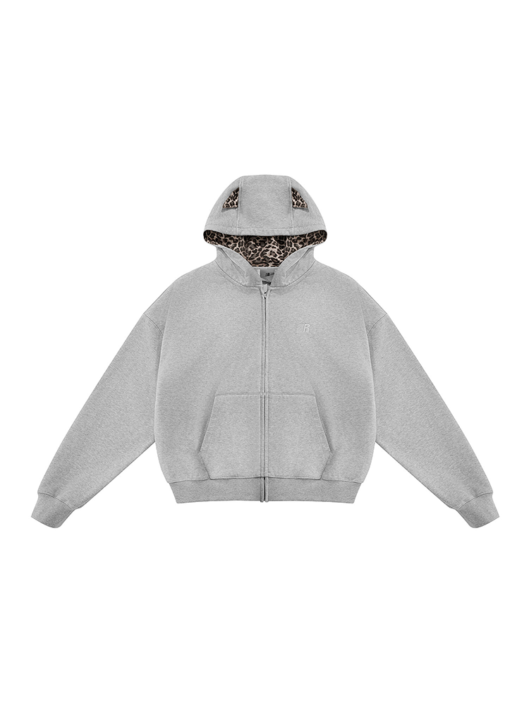 Flat lay of grey zip-up hoodie with leopard print lining and cat ears, neutral streetwear basic.