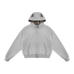 Flat lay of grey zip-up hoodie with leopard print lining and cat ears, neutral streetwear basic.