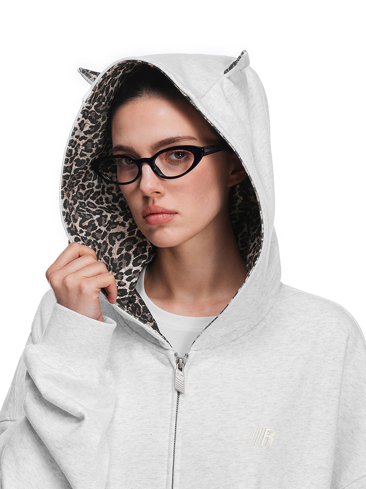 Close-up of model's head wearing the grey hoodie, focusing on cat ears design and leopard print lining texture.