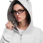 Close-up of model's head wearing the grey hoodie, focusing on cat ears design and leopard print lining texture.