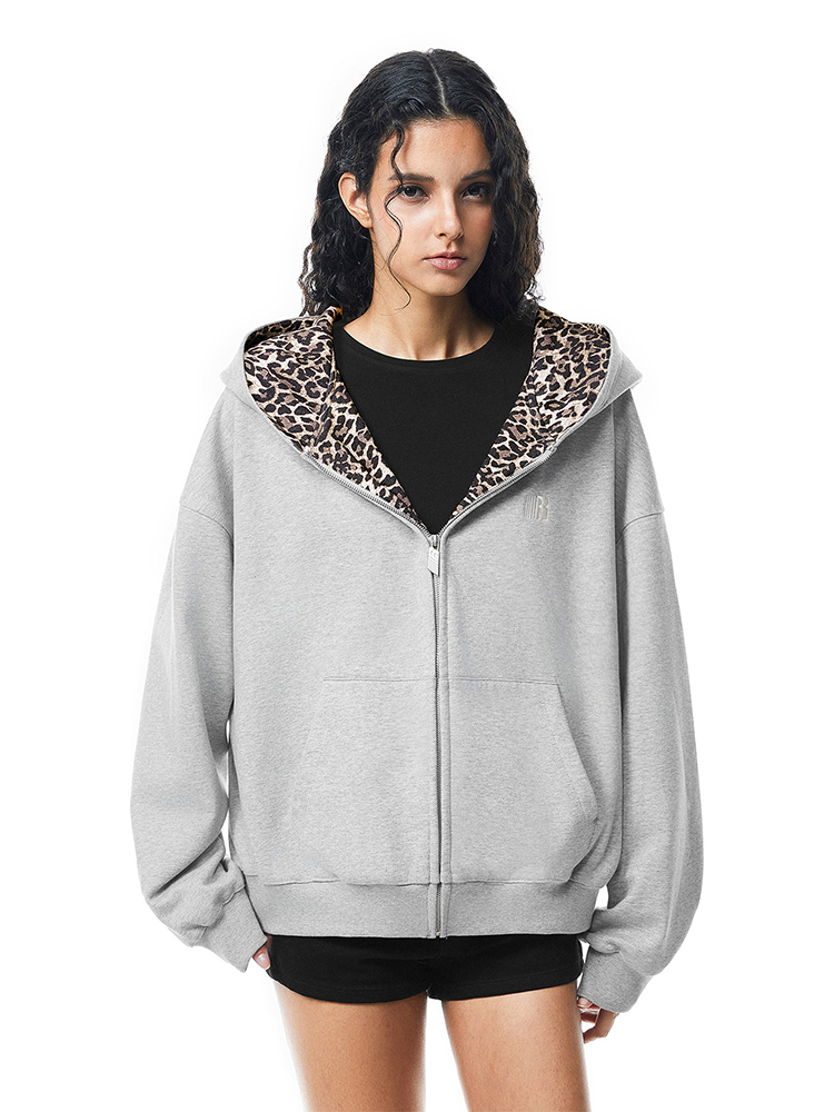 Model in grey zip-up hoodie featuring a leopard print lined hood with cute cat ears, Y2K streetwear aesthetic.
