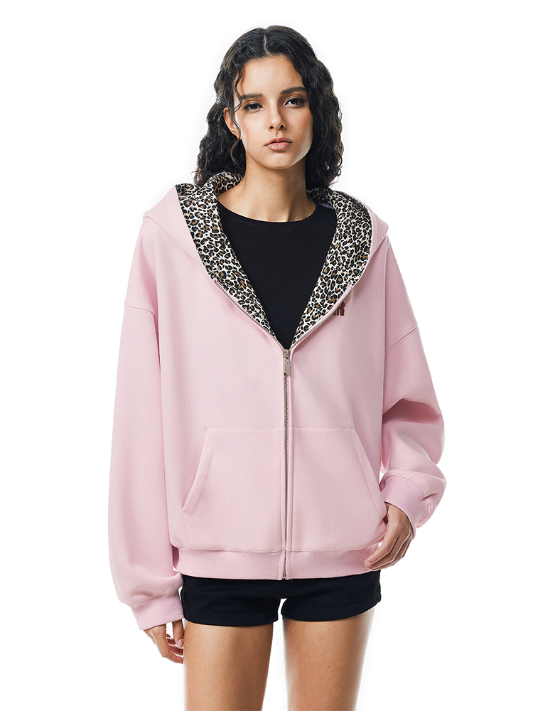 Front view of model in oversized pink zip-up hoodie with leopard print lined hood, soft punk style.