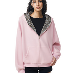 Front view of model in oversized pink zip-up hoodie with leopard print lined hood, soft punk style.