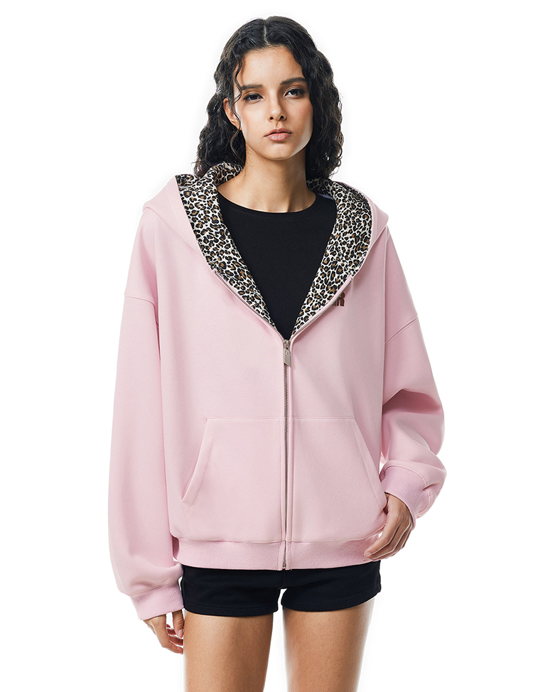 Front view of model in oversized pink zip-up hoodie with leopard print lined hood, soft punk style.