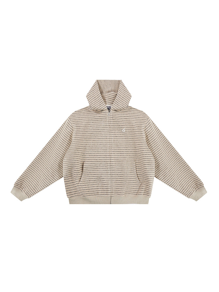 Studio flat lay of the cream textured hoodie, displaying the ribbed technical fabric, full-length zipper, and oversized silhouette.