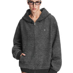 A model showcasing the charcoal black textured zip-up hoodie, featuring a relaxed boxy fit and integrated side pockets.