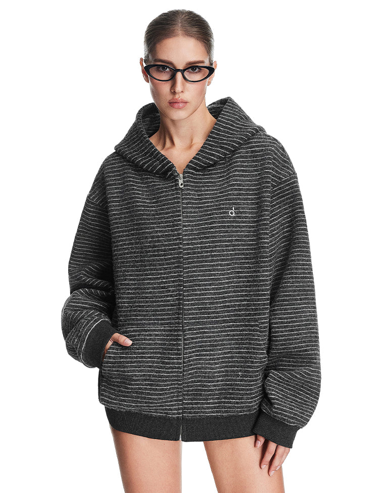 A model showcasing the charcoal black textured zip-up hoodie, featuring a relaxed boxy fit and integrated side pockets.