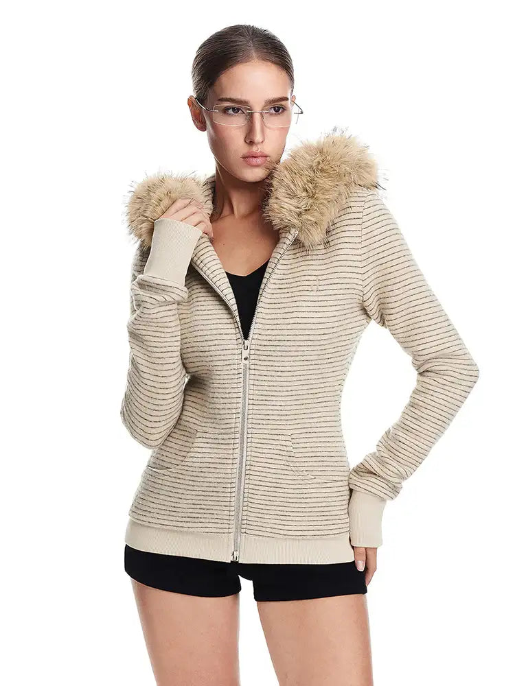 A model wearing a cream-colored, ribbed-knit hooded jacket with a brown faux fur-trimmed hood and black tank top underneath, posed against a white background.