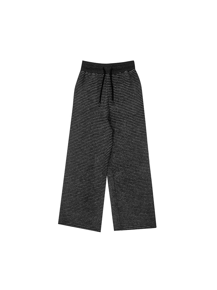 Studio flat lay of the black textured wide-leg pants, displaying the modern relaxed silhouette and high-quality fabric detail.