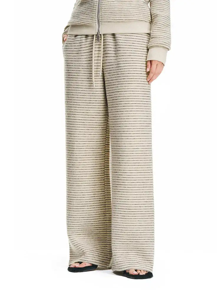 Vue de trois-quarts de côté du pantalon large texturé de couleur crème, mettant en valeur sa silhouette fluide et son tissu confortable à haute performance