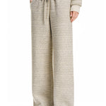 Three-quarter side view of the cream textured wide-leg pants, highlighting the flowing silhouette and high-performance comfort fabric.