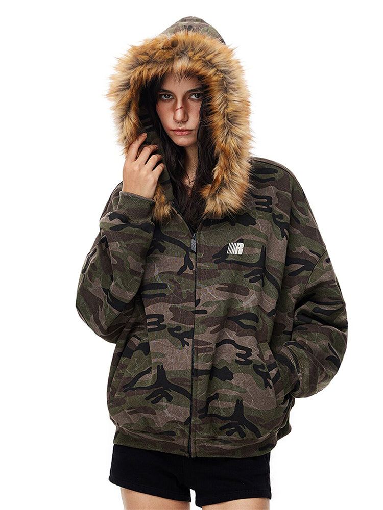 Front view of model in oversized camouflage hoodie with zip closure and small logo patch.