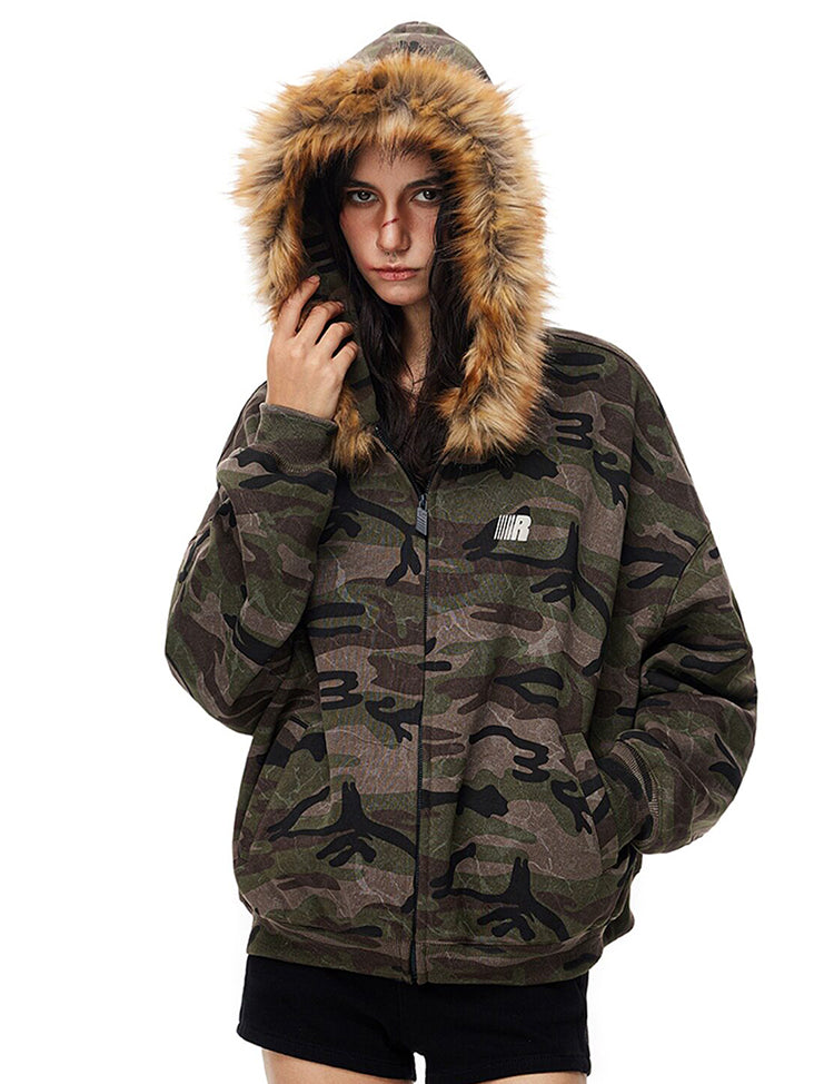 Front view of model in oversized camouflage hoodie with zip closure and small logo patch.