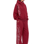 Model in burgundy zip hoodie and matching wide-leg track pants, side angle view