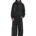 Male model wearing black oversized hoodie and matching wide-leg baggy sweatpants