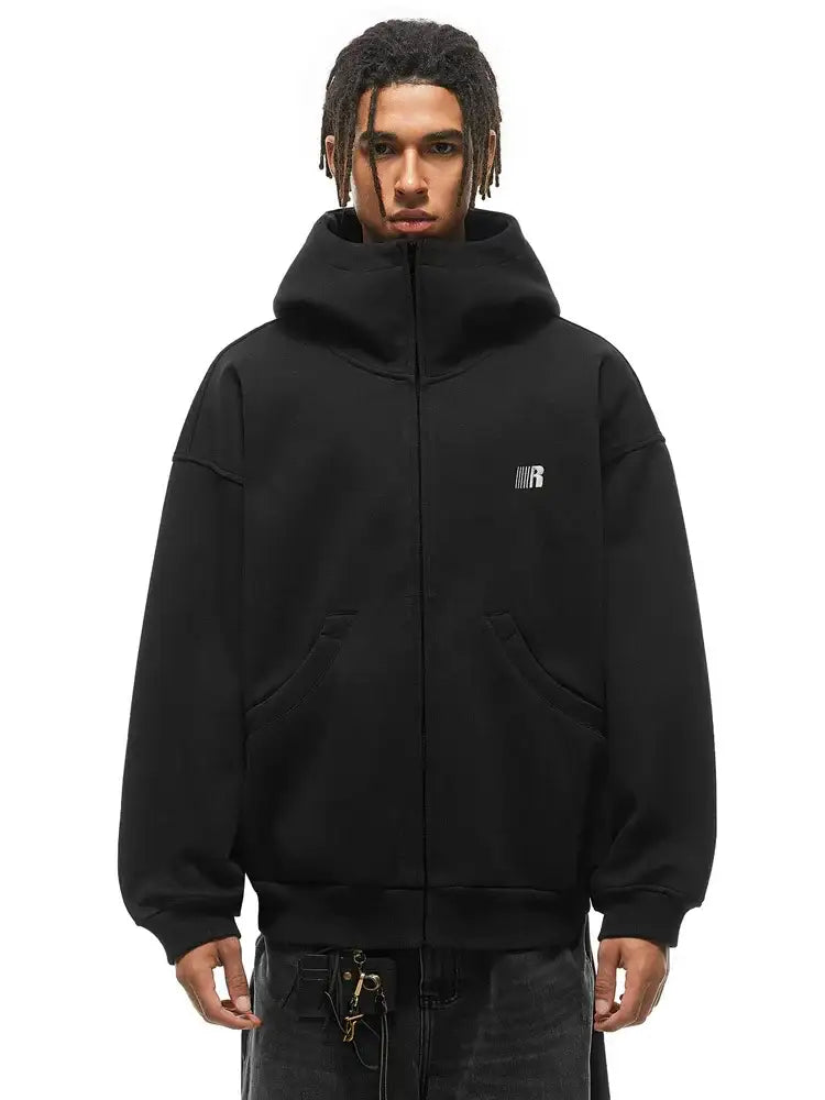 Male model in black oversized high-neck hoodie, showcasing the structured standing collar silhouette.