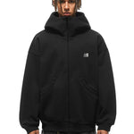 Male model in black oversized high-neck hoodie, showcasing the structured standing collar silhouette.