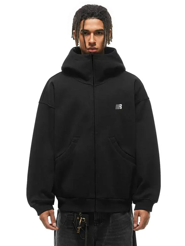 Modèle masculin portant un sweat à capuche oversize noir à col haut, mettant en valeur la silhouette structurée du col debout.