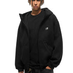 Front view of black zip-up hoodie featuring minimalist chest logo and baggy streetwear fit.