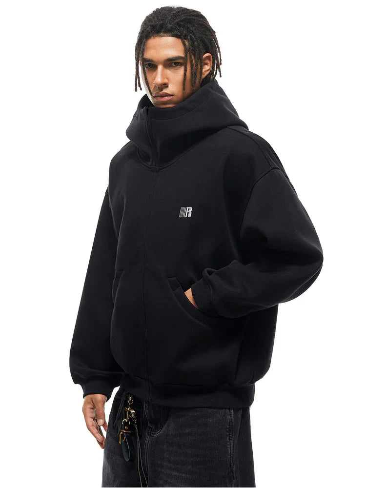Side profile of model in black hoodie, highlighting the structured hood and heavyweight fabric texture.
