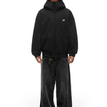 Full body shot of model styling black high-neck hoodie with wide-leg jeans, industrial edgy look.