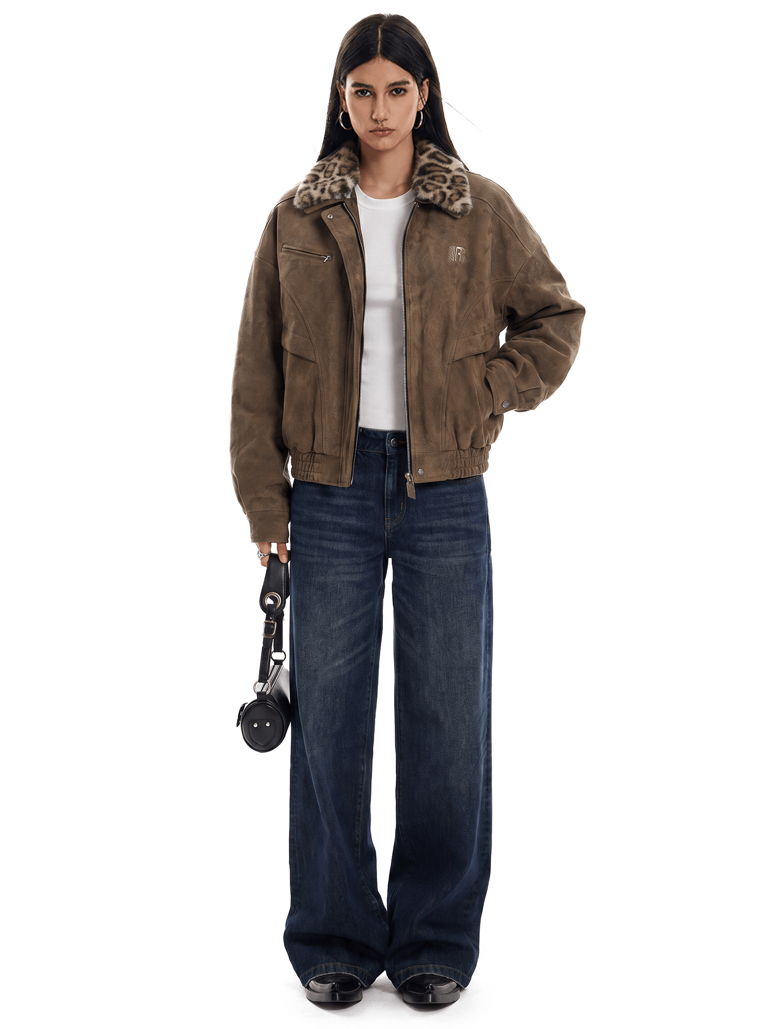 Person wearing a brown jacket with fur trim and dark jeans on a white background
