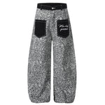 Front flat lay of grey leopard print baggy trousers featuring oversized black utility pockets.