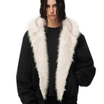 Eine Modelin trägt die schwarze thermische Zip-Jacke und präsentiert den flauschigen weißen Kragen sowie den lockeren Schnitt.