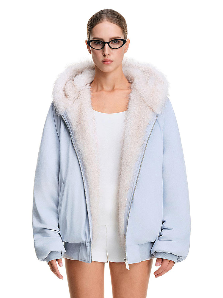 Front full shot of a model wearing a light pastel blue hooded jacket with a white faux fur trim, showing the fit.