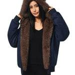 Eine Model trägt eine dunkelmarineblaue Damenjacke mit einer großen, flauschigen braunen Kunstfellkapuze und braunen Katzenohren