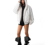 Eine Modelle posiert in der weißen Katzenohren-Kapuzenjacke und hebt die weiche, flaumige weiße Textur vor weißem Hintergrund hervor.