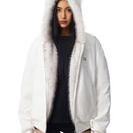 Nahaufnahme des Kopfbereichs und der Kapuze einer weißen Jacke, bei der das flauschige weiße Kunstfell-Katzenohr-Design hervorgehoben wird