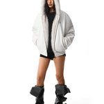 Ganzkörperaufnahme eines Modells, das die weiße Katzenohren-Thermalparka-Jacke mit schwarzen Schuhen trägt und den Gesamtlook zeigt.