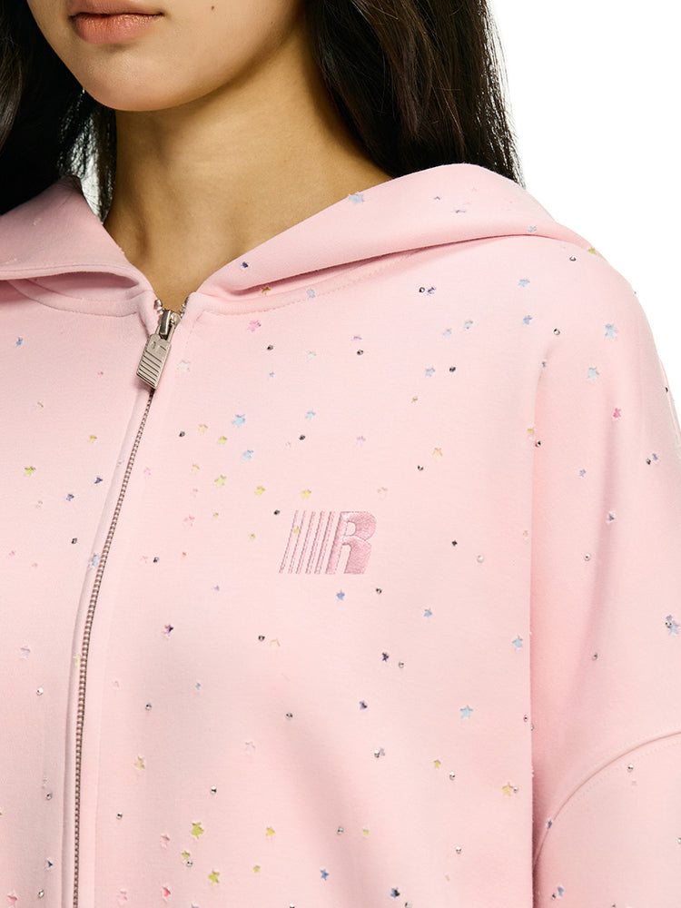 Close up detail of pink hoodie with colorful confetti dots and rhinestone star