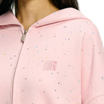 Close up detail of pink hoodie with colorful confetti dots and rhinestone star