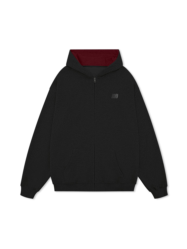 Flat lay of oversized black streetwear hoodie with crimson red hood lining interior.