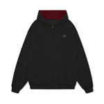 Flat lay of oversized black streetwear hoodie with crimson red hood lining interior.