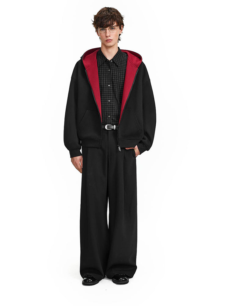 Full body shot of model in baggy black techwear hoodie and matching wide-leg trousers.