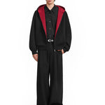 Full body shot of model in baggy black techwear hoodie and matching wide-leg trousers.