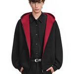 Front view of minimalist black hoodie with bold red contrast hood, oversized urban fashion.