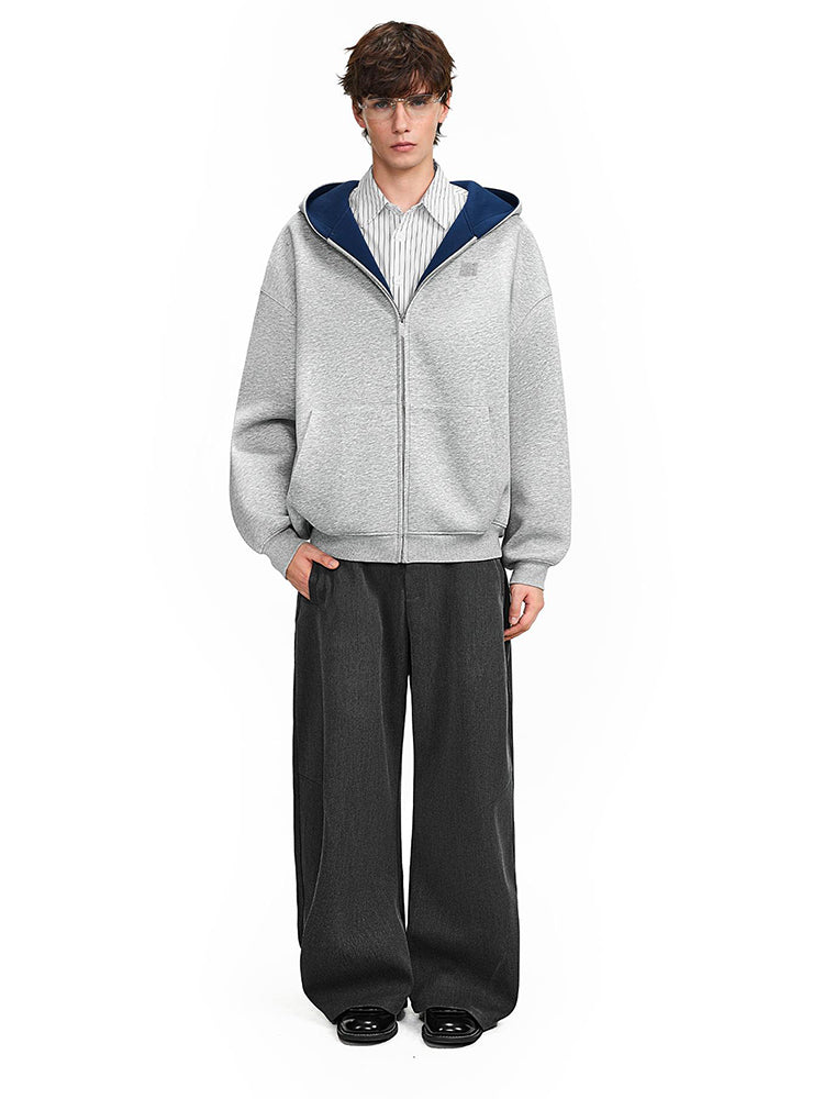 Male model wearing a grey heavy-weight hoodie with deep navy blue contrast lining, minimalist techwear look.