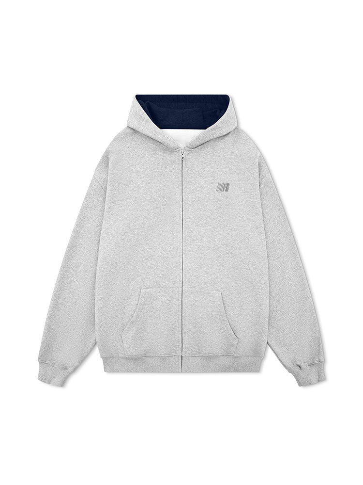 Flat lay of a grey oversized zip-up hoodie featuring a dark navy contrast hood interior.