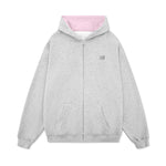 Product photography of a grey street-style hoodie with pastel pink interior lining and ribbed cuffs.